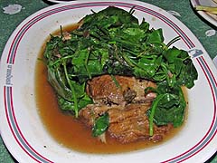 Roast duck hidden under leafy greens